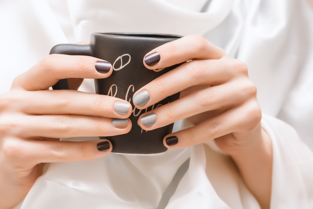 female-hands-with-glitter-nail-design-holding-black-cup (1)