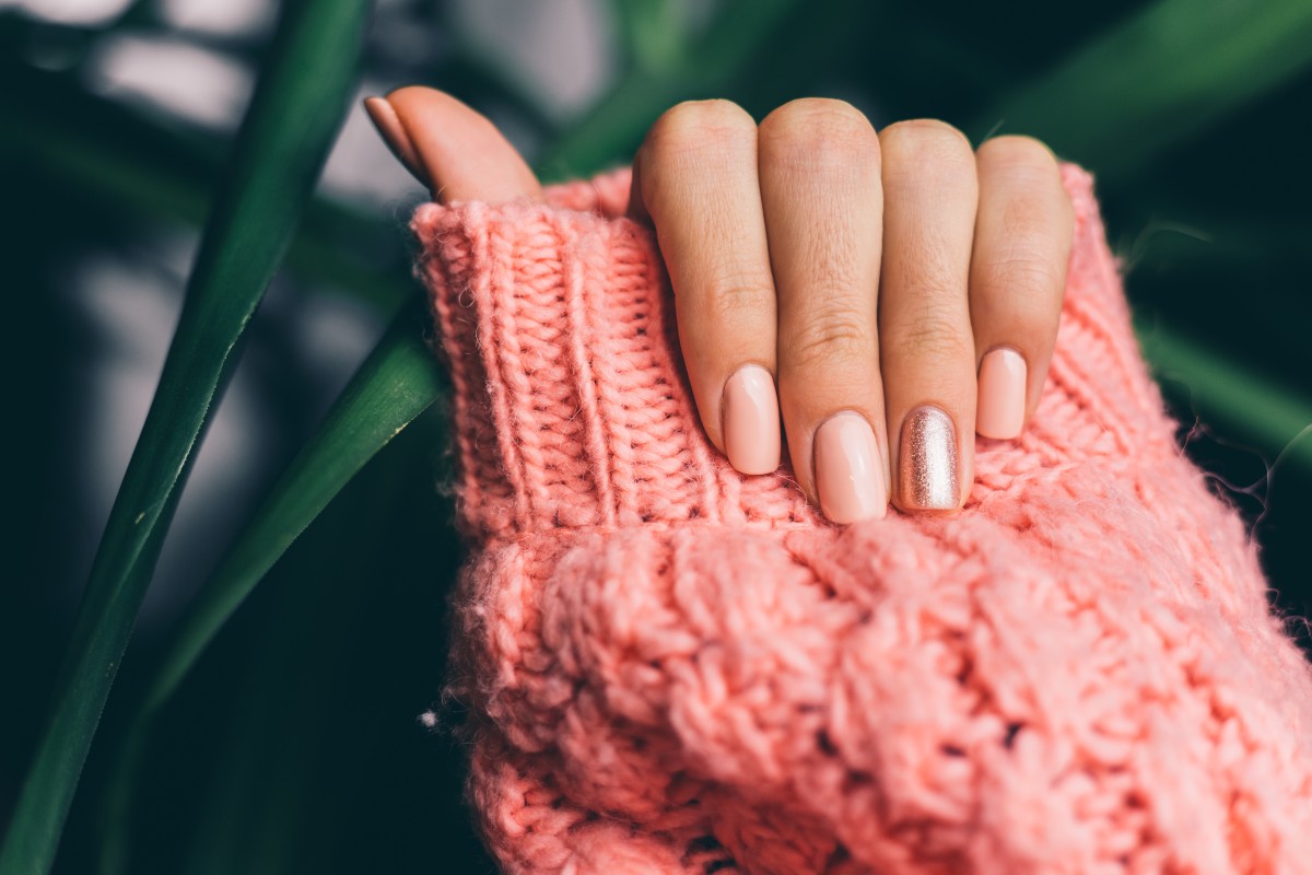 pretty-nude-color-manicure-one-finger-shiny-golden-knitted-pink-wool-pillover-background (1)